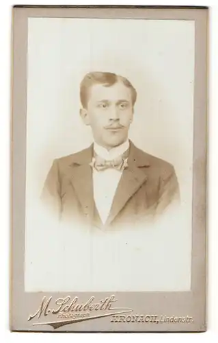 Fotografie M. Schuberth, Kronach, Portrait charmanter Herr mit Fliege im Anzug