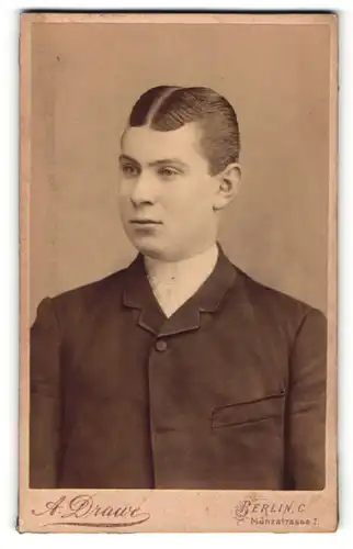 Fotografie A. Drawe, Berlin, Portrait dunkelhaariger junger Mann im Jackett