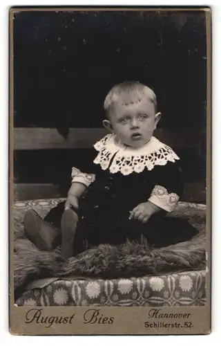 Fotografie August Bies, Hannover, Portrait blonder niedlicher Bube im bestickten Hemdchen