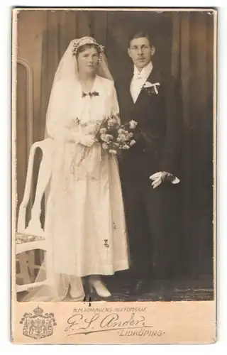 Fotografie G. S. Ander, Lidköping, Portrait bürgerliches Paar in hübscher Hochzeitskleidung mit Schleier u. Blumenstrauss