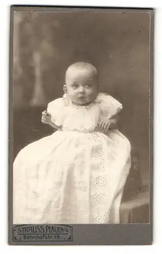 Fotografie Strauss, Plauen i. V., Portrait niedliches Baby im weissen Taufkleid