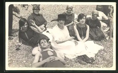 Foto-AK Damen sitzen mit einem Herrn im Badeanzug am Strand