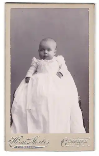Fotografie Herm. Moebes, Cönnern a. Saale, Portrait Baby im Taufkleid