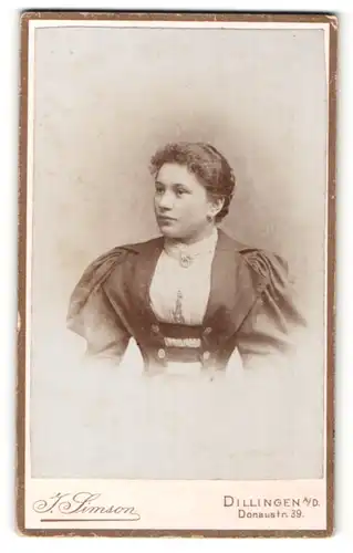 Fotografie J. Simson, Dillingen a. D., Portrait hübsches Fräulein mit lockigem Haar und Brosche am Kragen