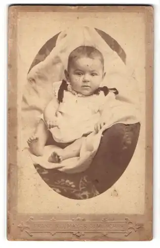 Fotografie Franz Neumayer, München, Baby in hellem Hemdchen mit dunklen Schleifen