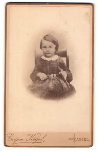 Fotografie Eugen Kegel, Cassel, Portrait kleines Mädchen im hübschen Kleid auf Stuhl sitzend