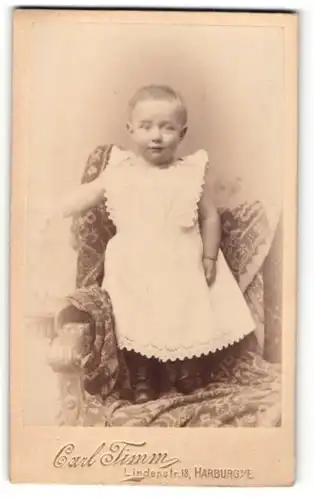 Fotografie Carl Timm, Harburg a. E., Portrait niedliches Kleinkind im weissen Kleidchen