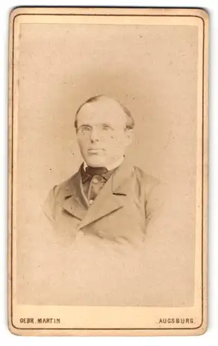 Fotografie Gebr. Martin, Augsburg, Portrait Herr im Anzug mit Brille