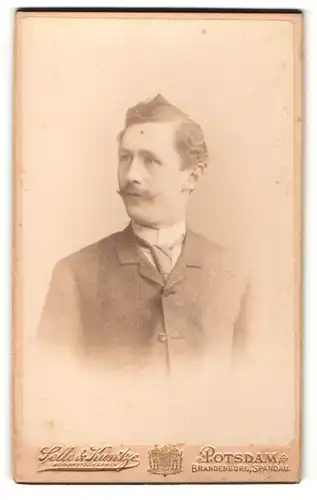 Fotografie Selle & Kuntze, Potsdam, Portrait modisch frisierter Mann mit Langbinder
