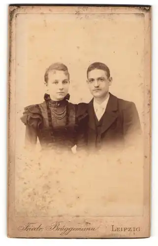 Fotografie Friedr. Brüggemann, Leipzig, Mann mit Anzug und Frau mit Kette