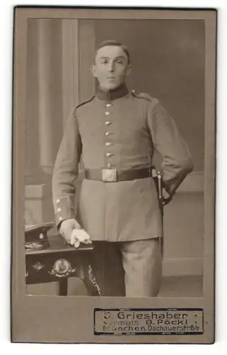 Fotografie J. Grieshaber, München, Portrait Soldat in Uniform mit Handschuhen an Tisch gelehnt