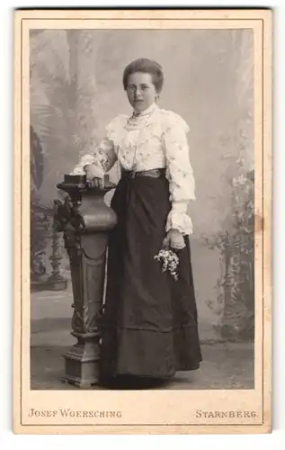 Fotografie Josef Woersching, Starnberg, Portrait Dame in hübscher Bluse u. Rock mit Blumen an Sockel gelehnt