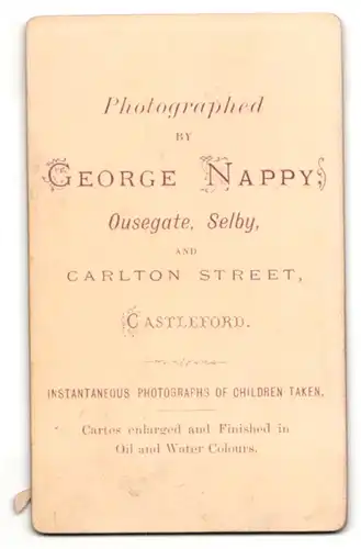 Fotografie George Nappy, Castleford, Mädchen im Kleid mit kurzen Haaren auf Tisch gelehnt