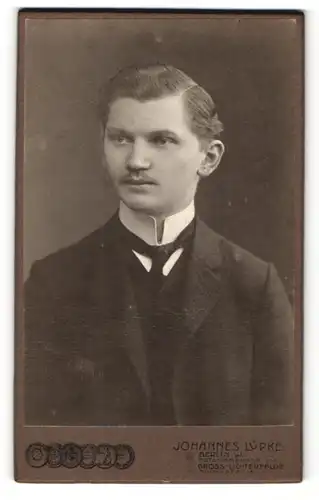Fotografie Johannes Lüpke, Berlin, Mann im Anzug mit dünnem Binder und schmalem Oberlippenbart