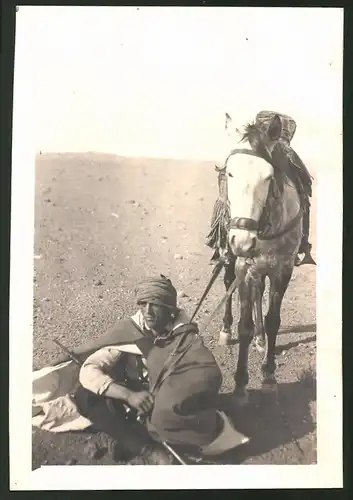 Fotografie Beduine mit Gewehr & Pferd macht Rast in der Wüste