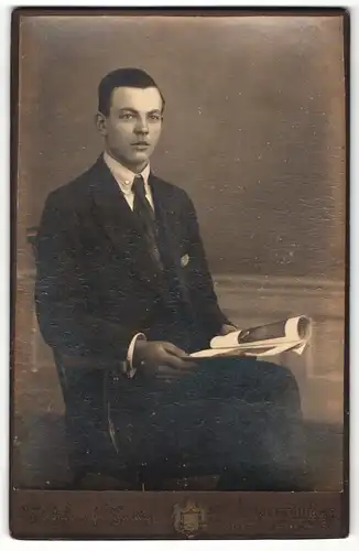 Fotografie Koenig, Altenburg-S, Portrait junger Herr im Anzug mit Zeitung auf Stuhl sitzend