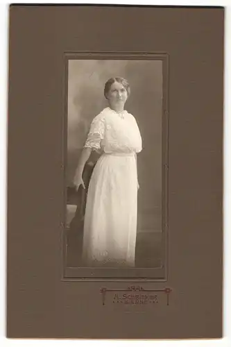 Fotografie H. Schricker, Bienne, Portrait junge Dame im weissen Kleid mit Ohrringen