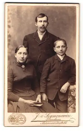 Fotografie J. v. Szymononricz, Graudenz, Frau im Kleid sitzend und Mann und Junge in Anzügen stehend
