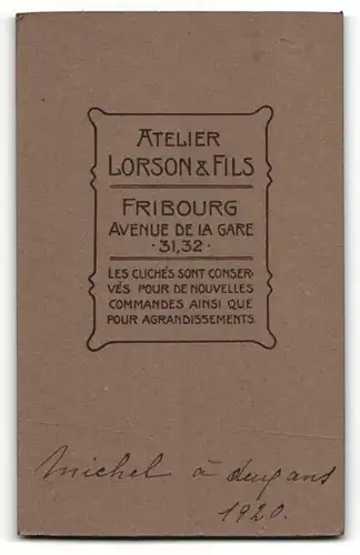 Fotografie Lorson & Fils, Fribourg, Kleinkind auf Stuhl neben Tisch mit Plüschtier