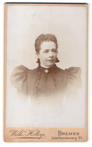 Fotografie Wilh. Hottorp, Bremen, Dame in dunklem Kleid mit Spitze am Revers und Puffärmeln