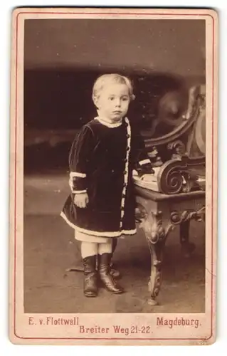 Fotografie E. v. Flottwell, Magdeburg, Portrait kleines Mädchen im Samtkleid mit Buch an Stuh gelehnt