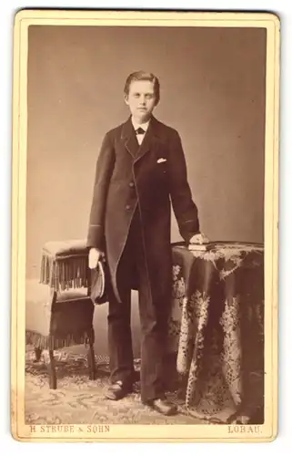 Fotografie H. Strube & Sohn, Löbau i. S., junger Mann im Anzug mit Mütze in der Hand