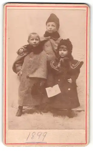 Fotografie unbekannter Fotograf und Ort, Portrait drei kleine Kinder in Wintermänteln