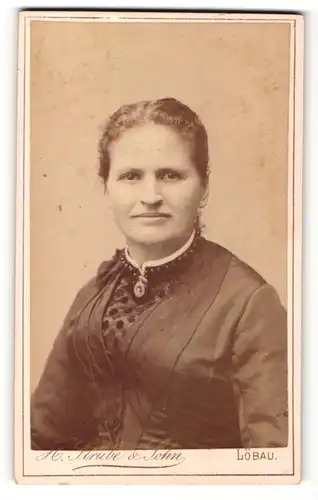 Fotografie H. Strube & Sohn, Löbau i/S., Frau im Kleid mit direktem Blick zum Fotografen