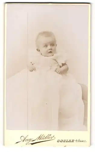 Fotografie Aug. Müller, Goslar / Harz, Portrait zuckersüsses Baby im weissen Taufkleidchen