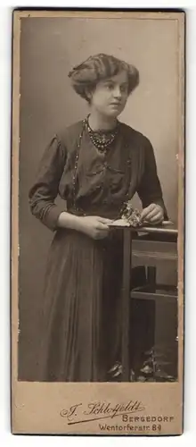 Fotografie Atelier Schlotfeld, Bergedorf, hübsche junge Dame mit Halskette trägt dunkeles Kleid