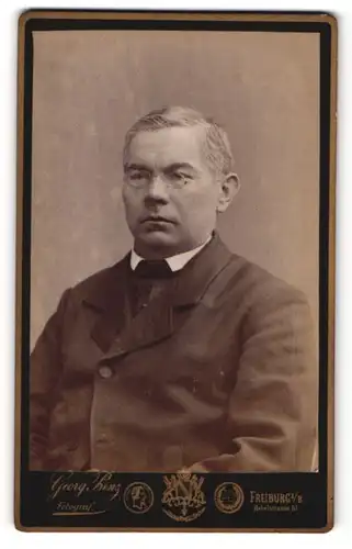 Fotografie Georg Prinz, Freiburg i/B., Portrait Mann mit Brille im Jacket