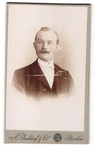 Fotografie A. Jandorf & Co., Berlin, Mann im Anzug mit Moustache Bart und heller Fliege