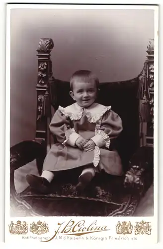 Fotografie J. B. Ciolina, Frankfurt a. M., Mannheim, Portrait niedliches Kleinkind im hübschen Kleid auf Stuhl sitzend