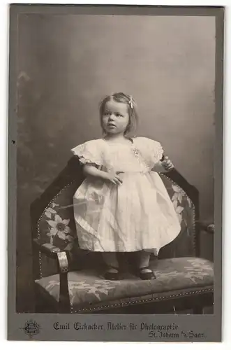 Fotografie Emil Eichacker, St. Johann / Saar, Mädchen im weissen Kleid auf Sessel stehend