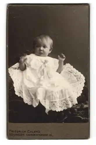 Fotografie Friedrich Ehlers, Solingen, Kleinkind im Kleidchen mit Armen hochgehoben