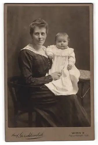 Fotografie Josef Gerschkowitsch, Wien, Portrait lächelnde Mutter mit Kleinkind im Arm auf Stuhl sitzend