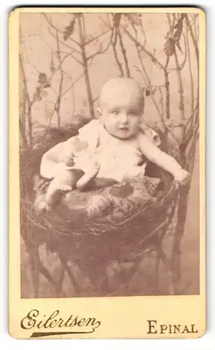 Fotografie Eilertsen, Epinal, Portrait niedliches Baby im weissen Hemd im Körbchen siztend