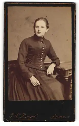 Fotografie F. X. Siegel, Kempten, Portrait junge Dame mit zurückgebundenem Haar am Tisch sitzend