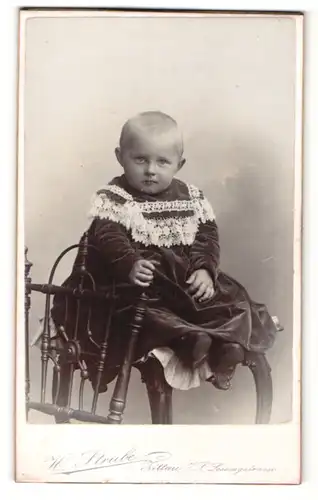 Fotografie H. Strube, Zittau i/S., Kleinkind im Kleidchen auf Stuhl sitzend