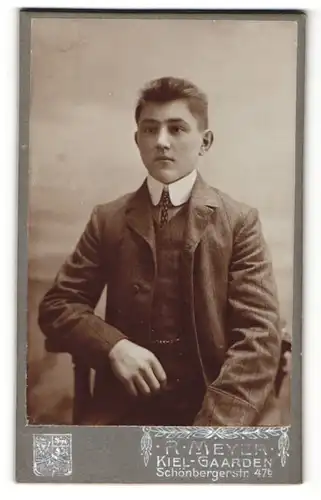 Fotografie R. Meyer, Kiel, junger Mann im Anzug auf Stuhl sitzend