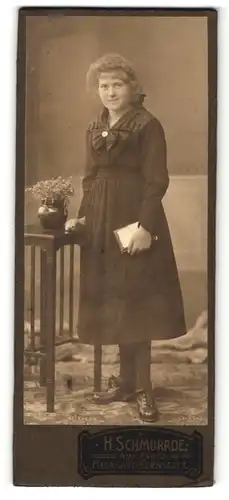 Fotografie H. Schmorrde, Herrnhut-Bernstadt, Frau im Kleid stehend mit Buch in der Hand und offenen Haaren