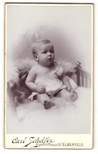 Fotografie Carl Schäfer, Elberfeld, Baby auf Felldecke sitzend