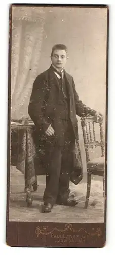Fotografie Paul Lange Ww., Ludwigslust, Portrait bürgerlicher Herr im Anzug mit Krawatte an Stuhl gelehnt