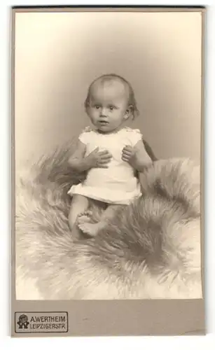 Fotografie A. Wertheim, Berlin, Portrait niedliches Kleinlind im weissen Hemd auf Fell sitzend