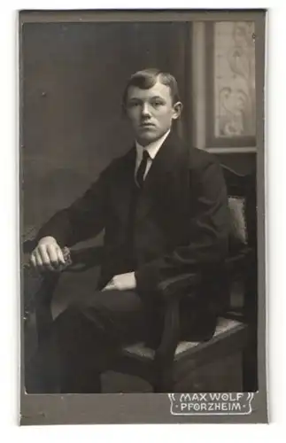 Fotografie Max Wolf, Pforzheim, junger Mann im Anzug auf Stuhl sitzend