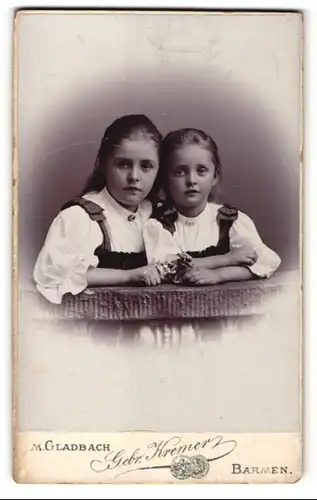 Fotografie Gebr. Kremer, M. Gladbach & Barmen, Portrait zwei kleine Mädchen mit Blumen an Geländer gelehnt