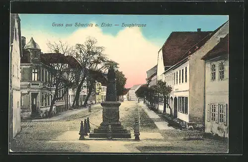 AK Schweinitz / Elster, Hauptstrasse mit Kriegerdenkmal und Gebäudeansicht