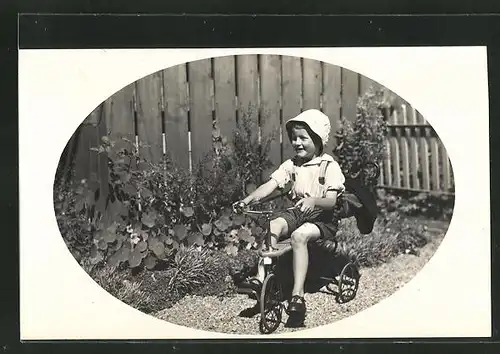 Foto-AK Kleiner Bub auf Dreirad im Garten