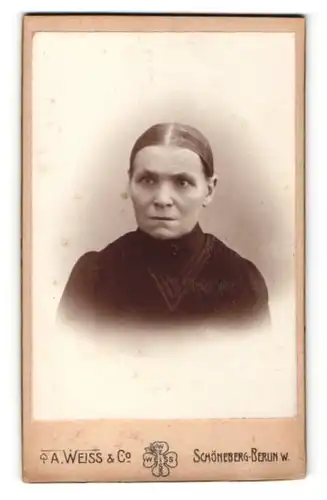 Fotografie A. Weiss & Co., Berlin-Schöneberg, Portrait grimmige Hausfrau
