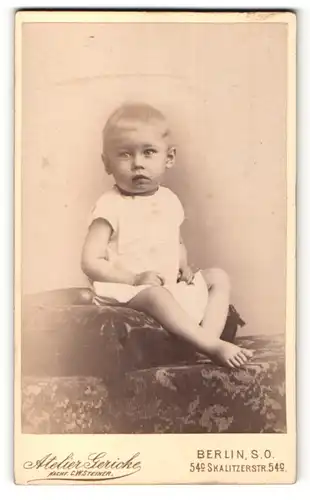 Fotografie Atelier Gericke, Berlin-SO, Portrait niedliches Kleinkind im weissen Hemd auf Kissen sitzend